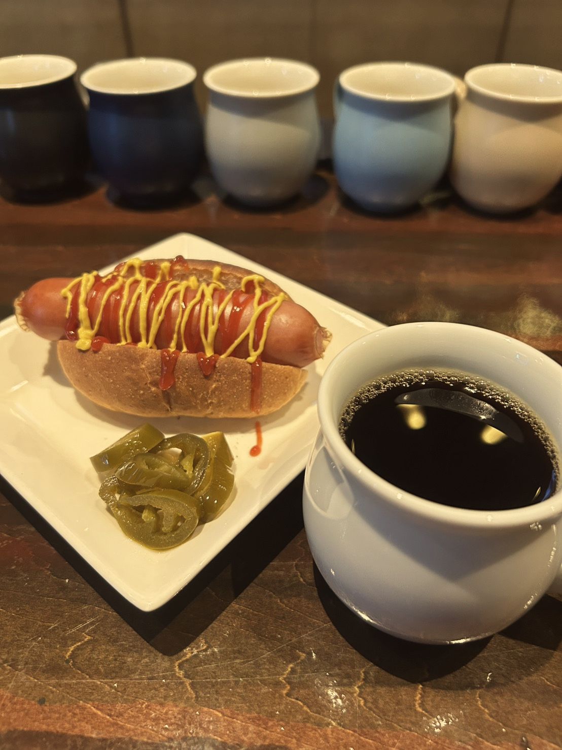 ホットドッグとハラペーニョ、白いカップの珈琲