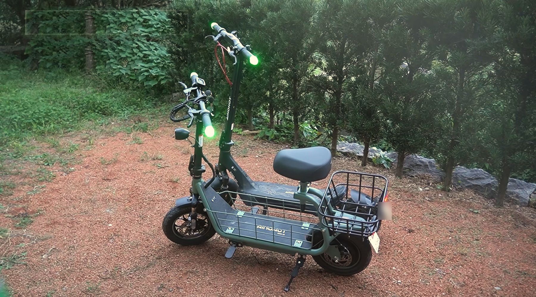 山の敷地に止めた、座るタイプの電動バイク（かご付き）